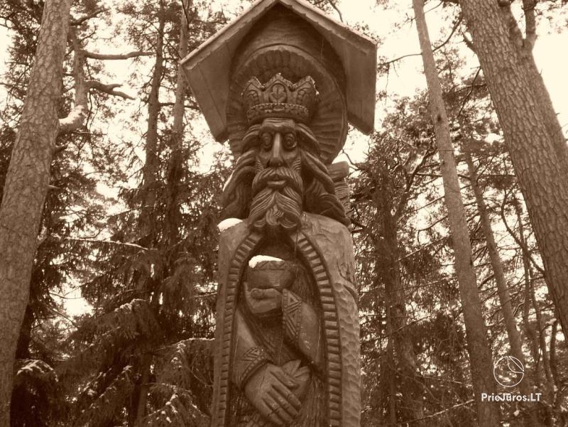 Ekspozycja wzgórz czarownic z drewnianymi rzeźbami w Juodkrante